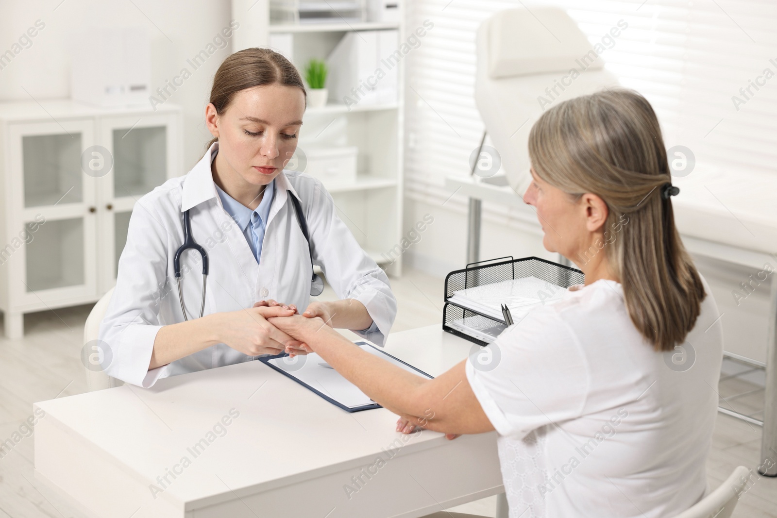 Photo of Arthritis symptoms. Doctor examining patient's wrist in hospital