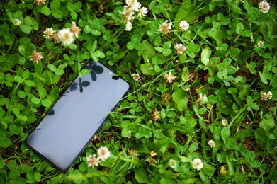 Photo of Smartphone on green grass outdoors, space for text. Lost and found
