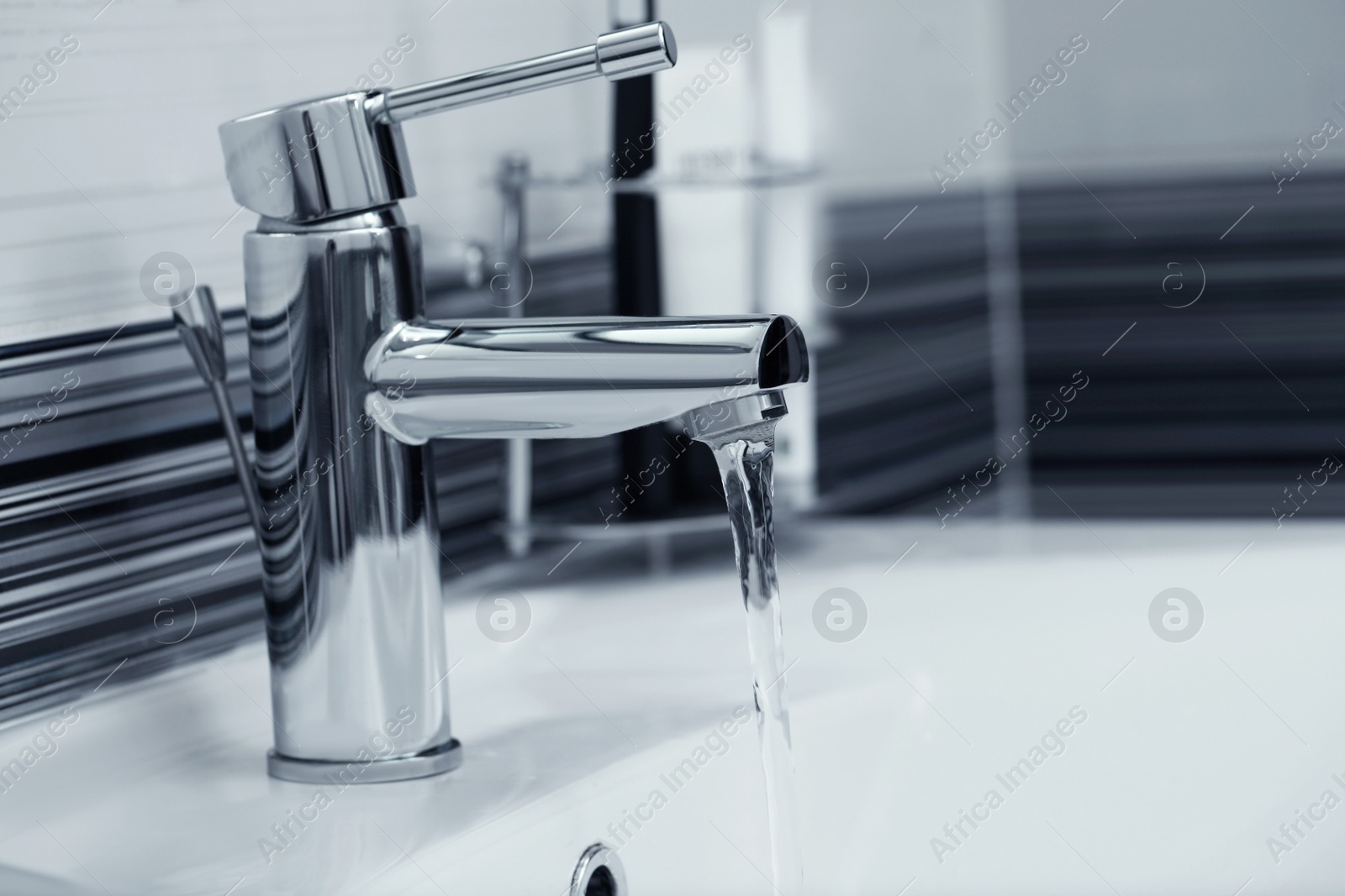 Photo of Stream of water flowing from tap in bathroom