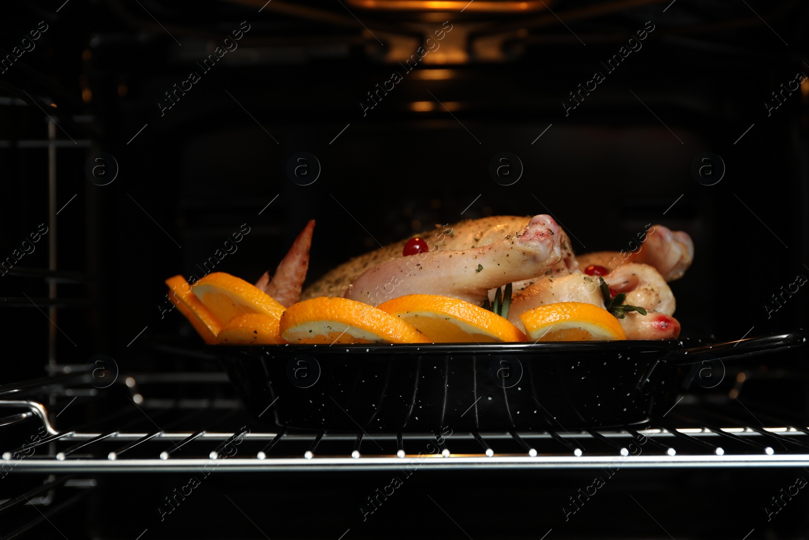 Photo of Chicken with orange slices baking in oven