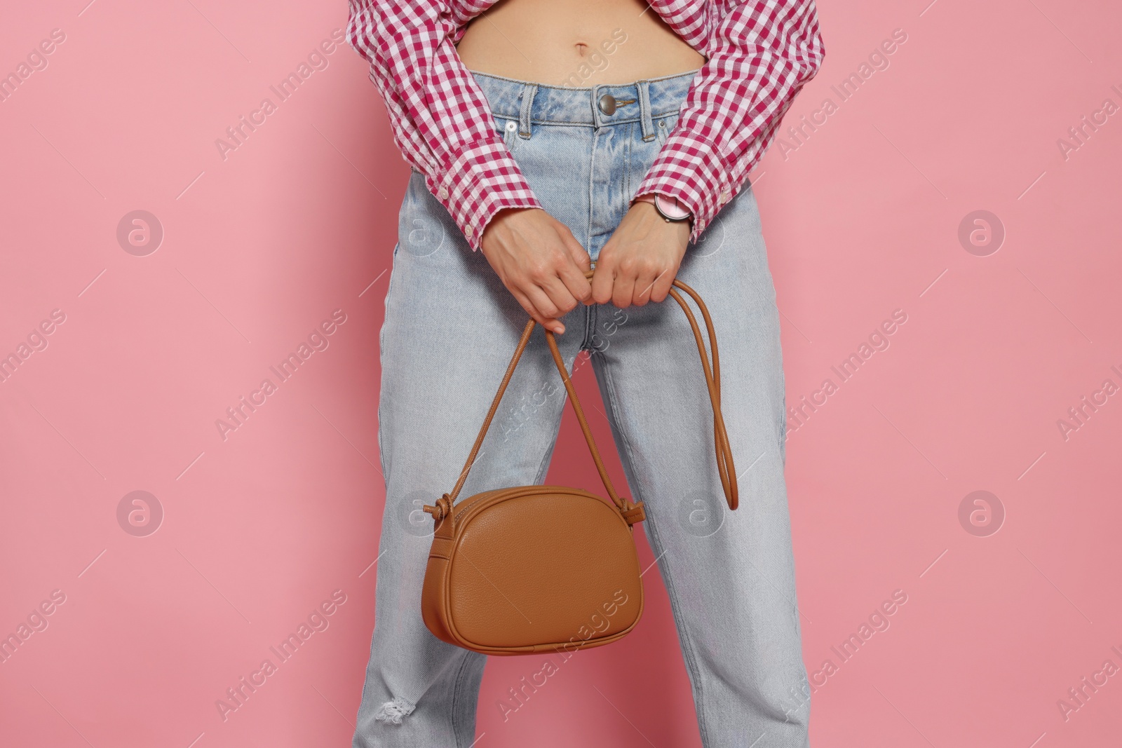Photo of Woman in fashionable outfit with stylish bag on pink background, closeup