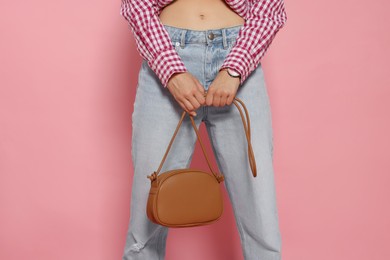 Photo of Woman in fashionable outfit with stylish bag on pink background, closeup