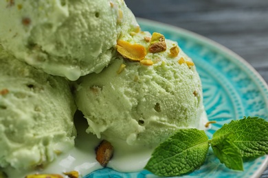 Photo of Delicious green ice cream served on blue plate, closeup