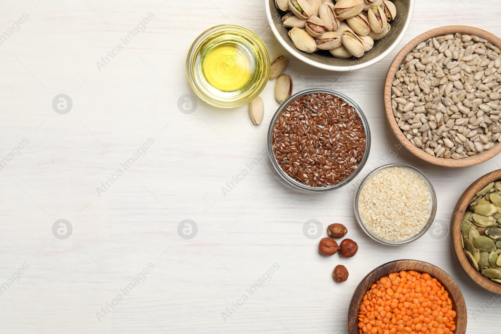 Photo of Different products high in vegetable fats on white wooden table, flat lay. Space for text