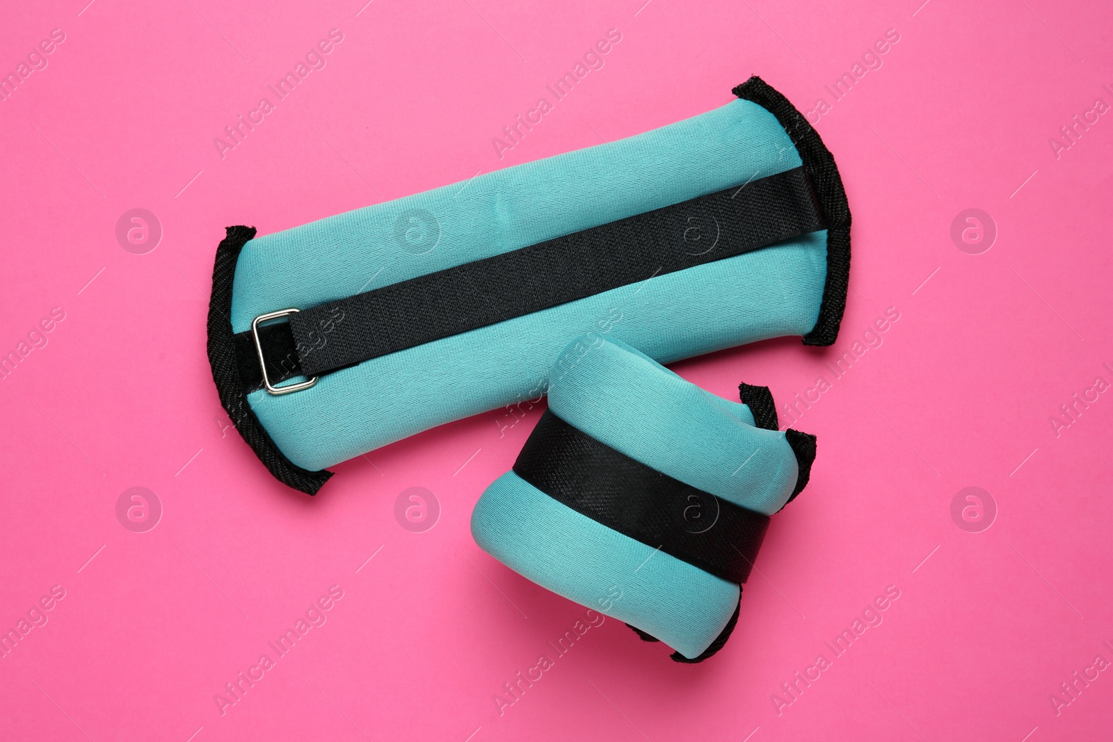 Photo of Turquoise weighting agents on pink background, flat lay