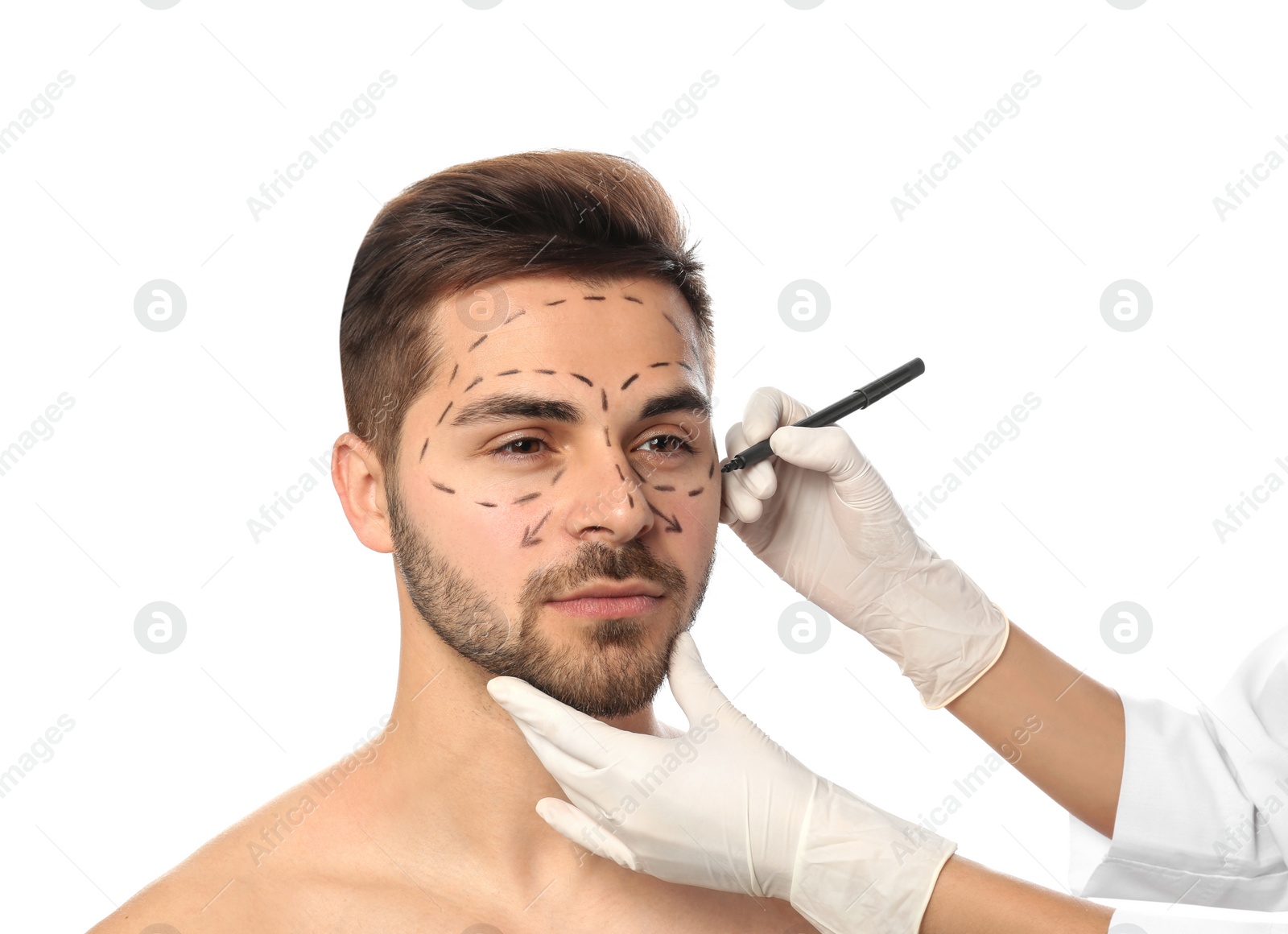 Photo of Doctor drawing marks on man's face for cosmetic surgery operation against white background