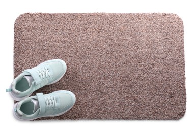 Stylish door mat with shoes on white background, top view