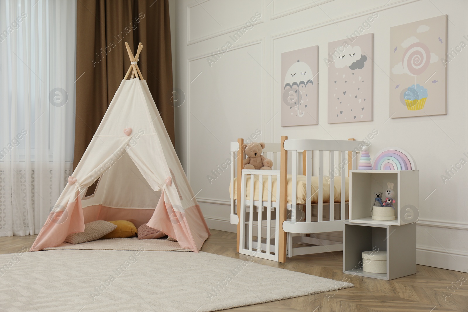 Photo of Cute baby room interior with crib and play tent