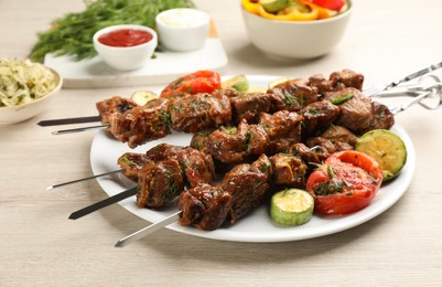 Photo of Metal skewers with delicious meat and vegetables served on white wooden table