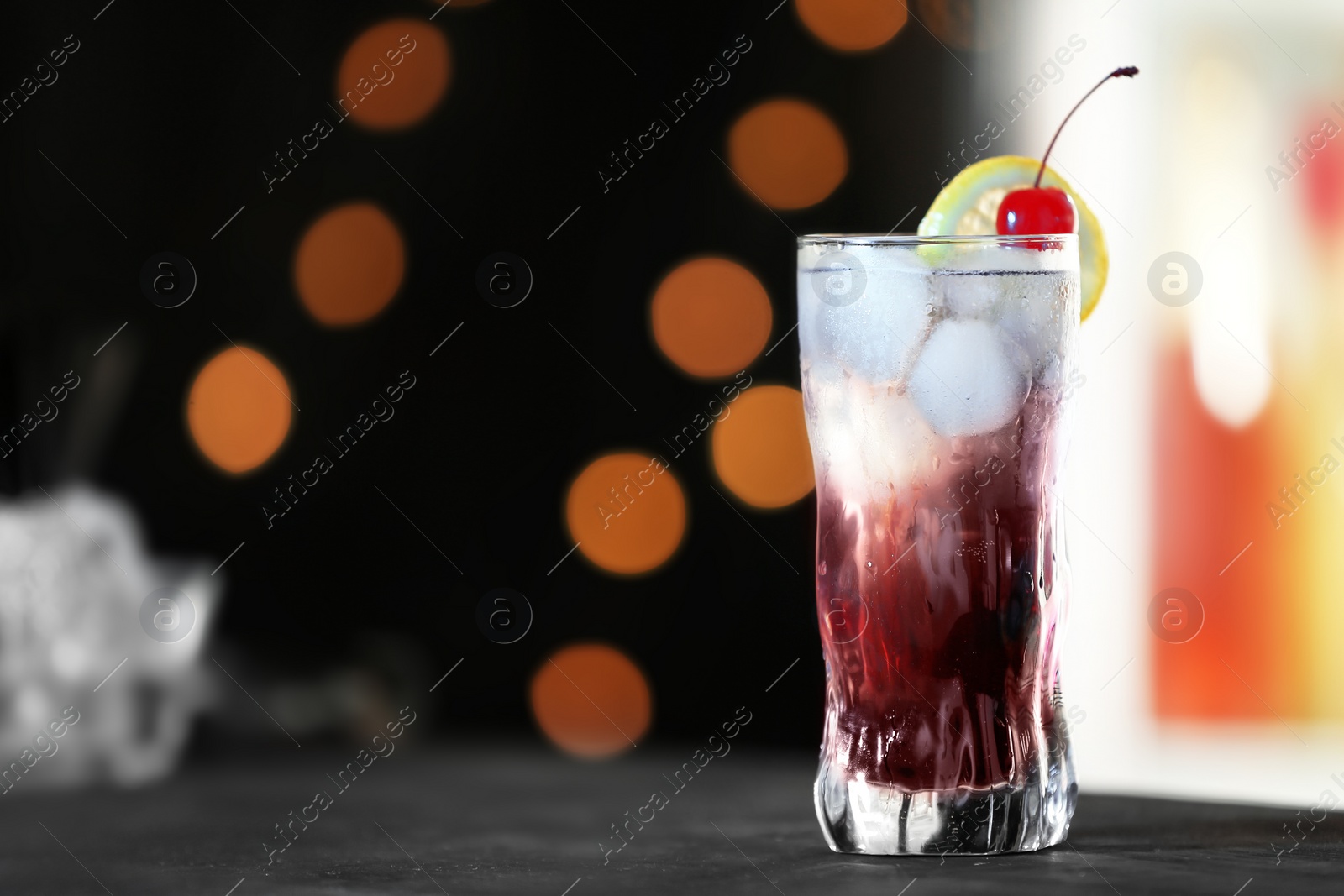 Photo of Fresh alcoholic cocktail with lemon and cherry on bar counter, space for text