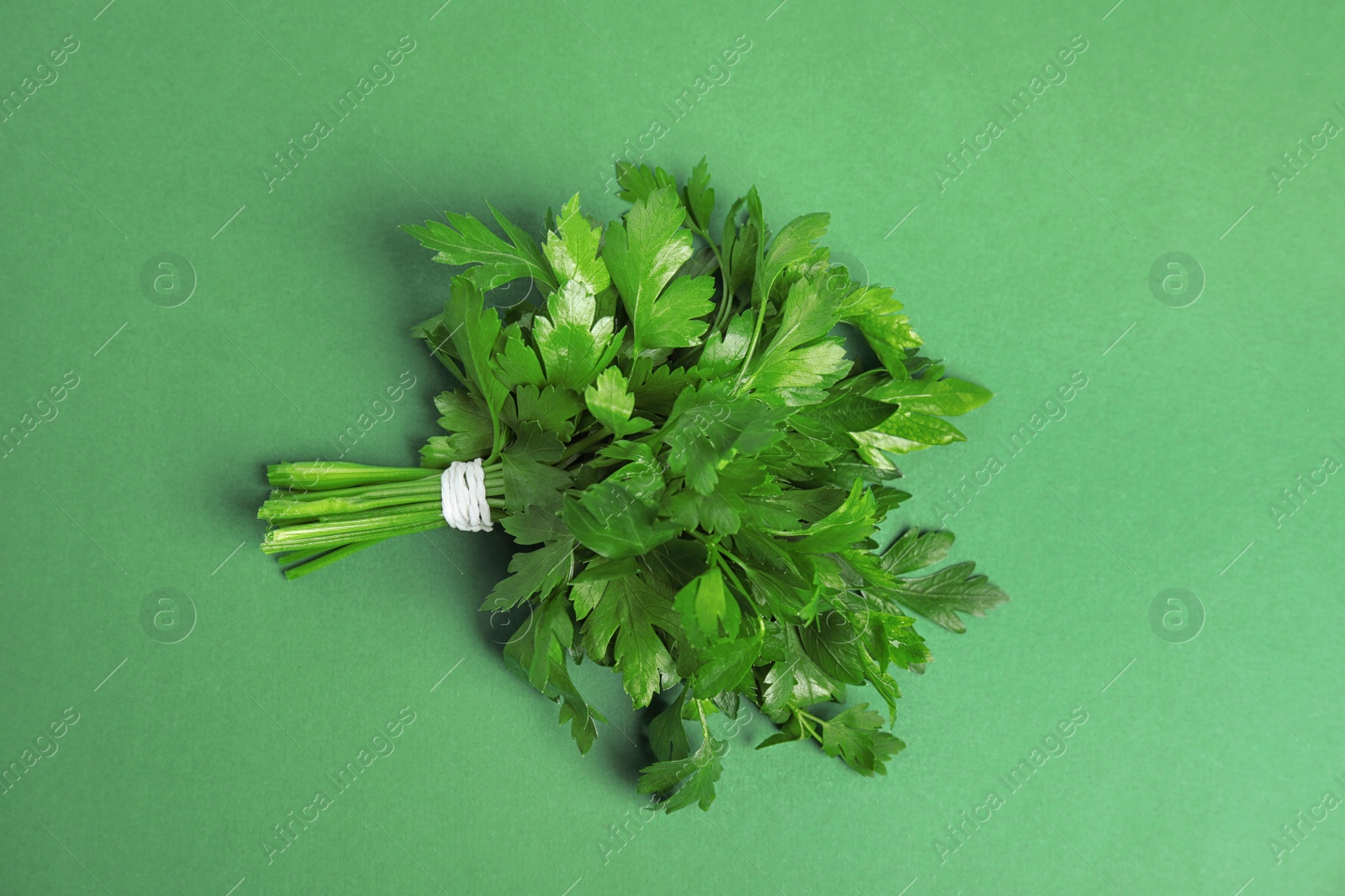 Photo of Bunch of fresh green parsley on color background, view from above