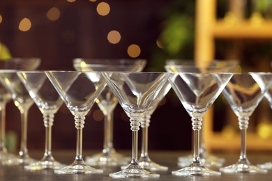 Photo of Empty martini glasses on table against blurred background