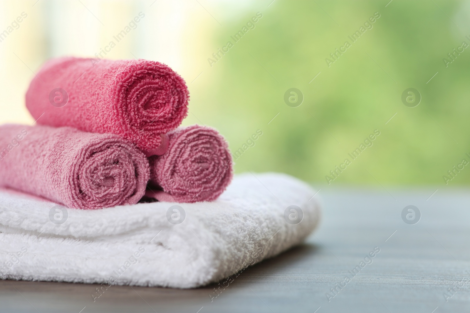 Photo of Clean towels on table against blurred background. Space for text