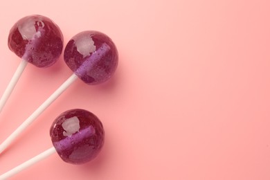 Tasty lollipops on pink background, flat lay. Space for text