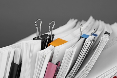 Photo of Pile of documents with colorful binder clips, closeup