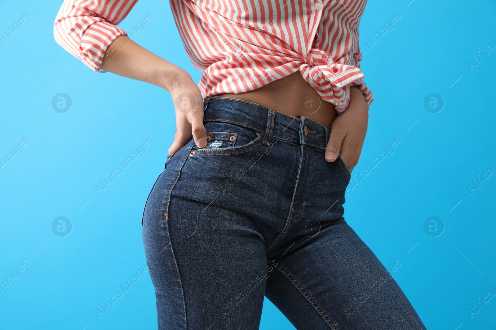 Photo of Woman wearing jeans on blue background, closeup