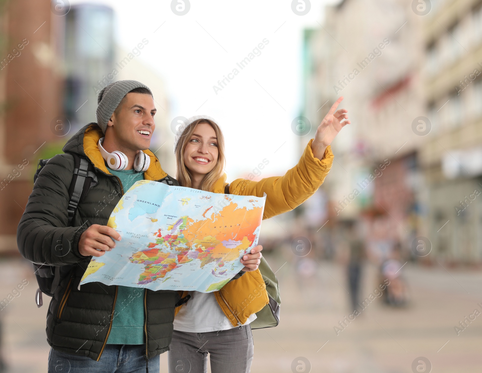 Image of Happy travelers with map in foreign city. Vacation trip