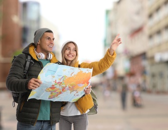 Image of Happy travelers with map in foreign city. Vacation trip