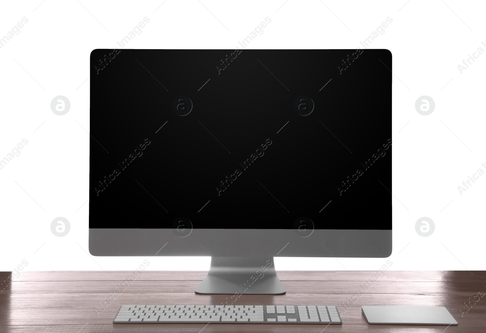 Photo of Modern computer with blank monitor screen and peripherals on wooden table against white background