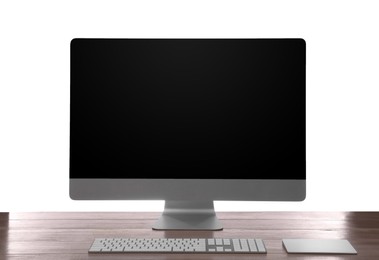 Photo of Modern computer with blank monitor screen and peripherals on wooden table against white background