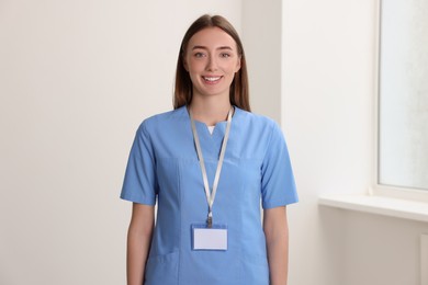 Happy doctor with blank badge in hospital