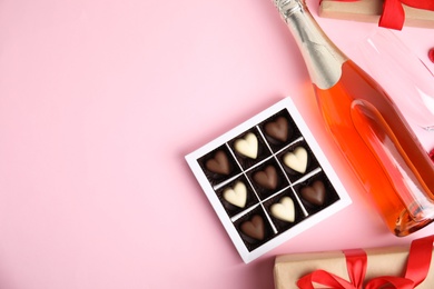 Flat lay composition with heart shaped chocolate candies on pink background, space for text. Happy Valentine's day