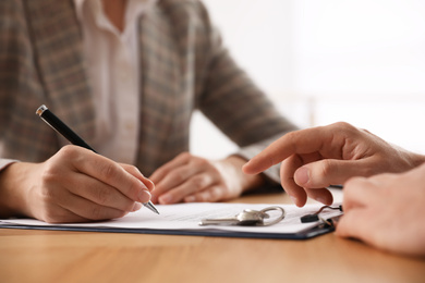 Photo of Real estate agent working with client in office, closeup