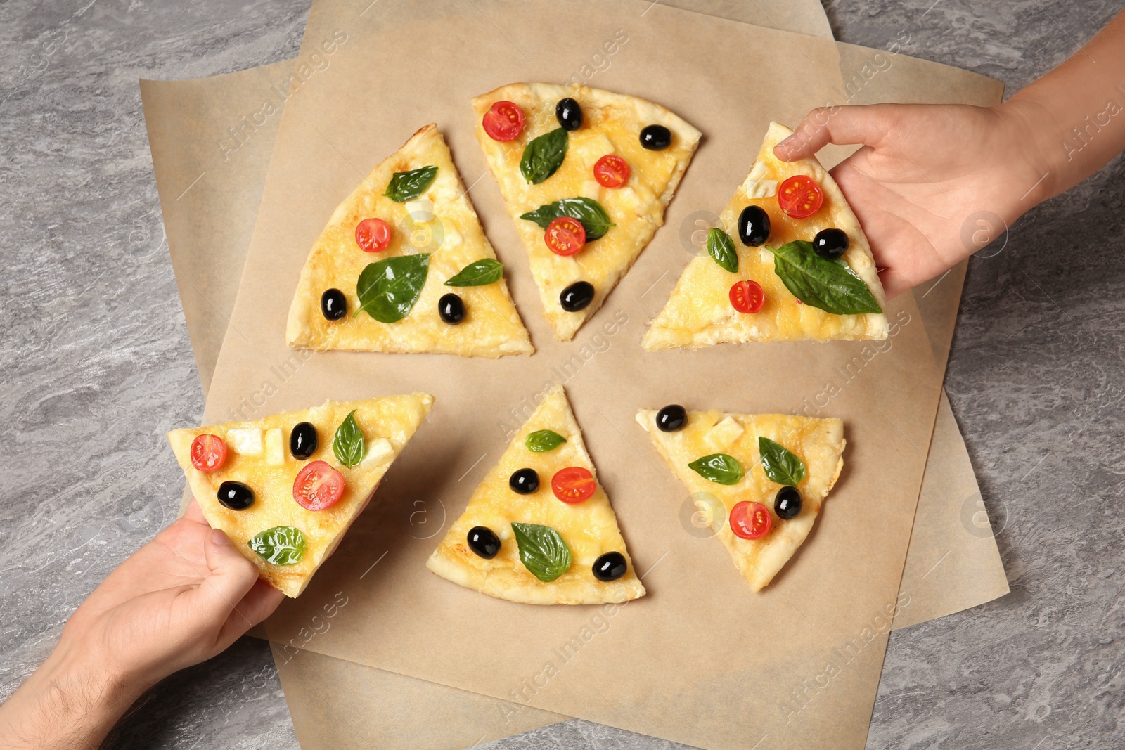 Photo of People taking tasty homemade pizza slices from table, top view