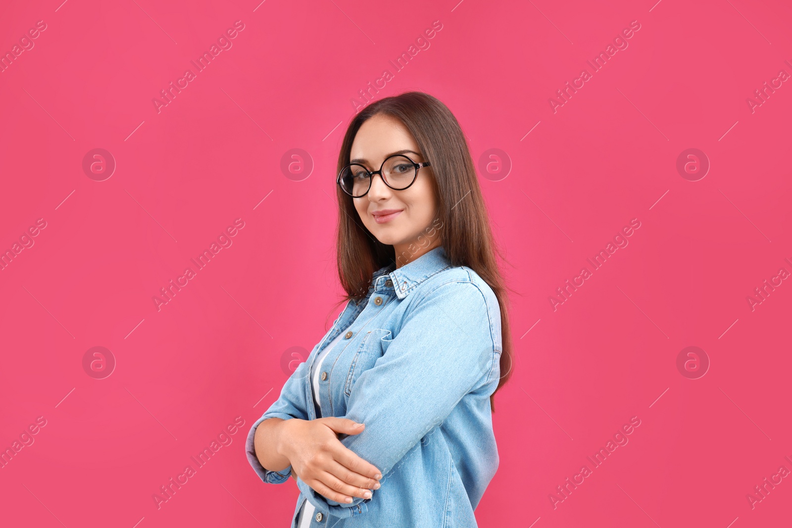 Photo of Beautiful young woman with glasses on crimson background