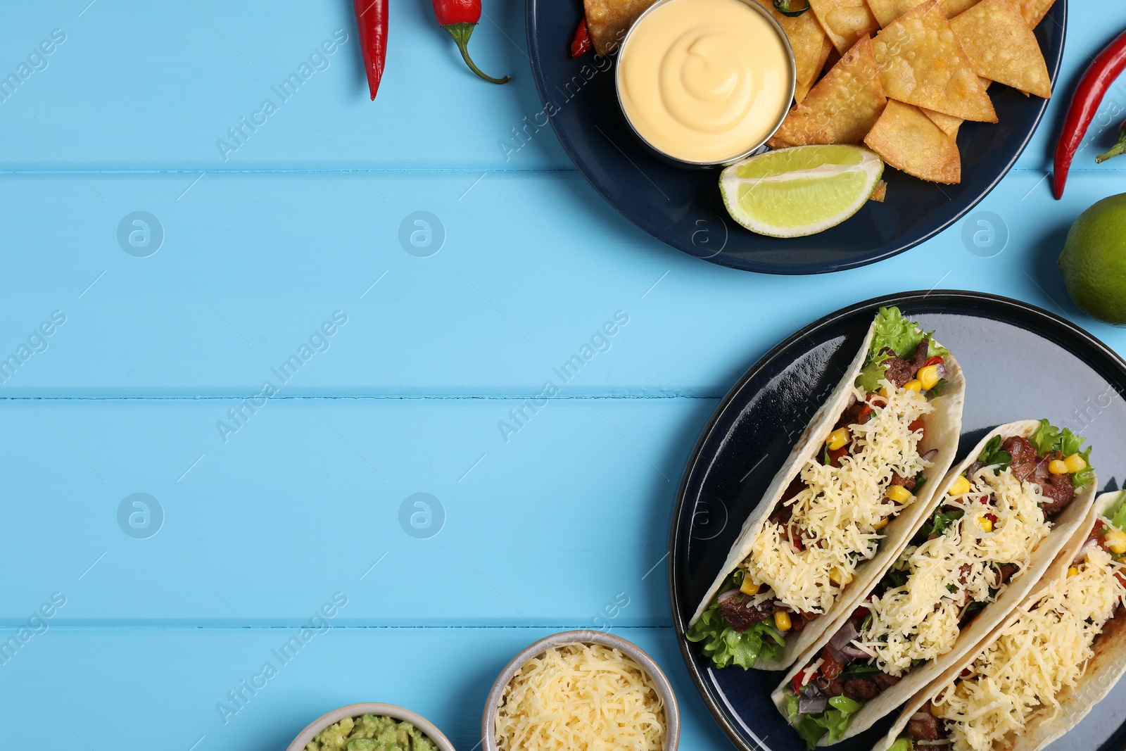 Photo of Flat lay composition with delicious tacos on light blue wooden table, space for text