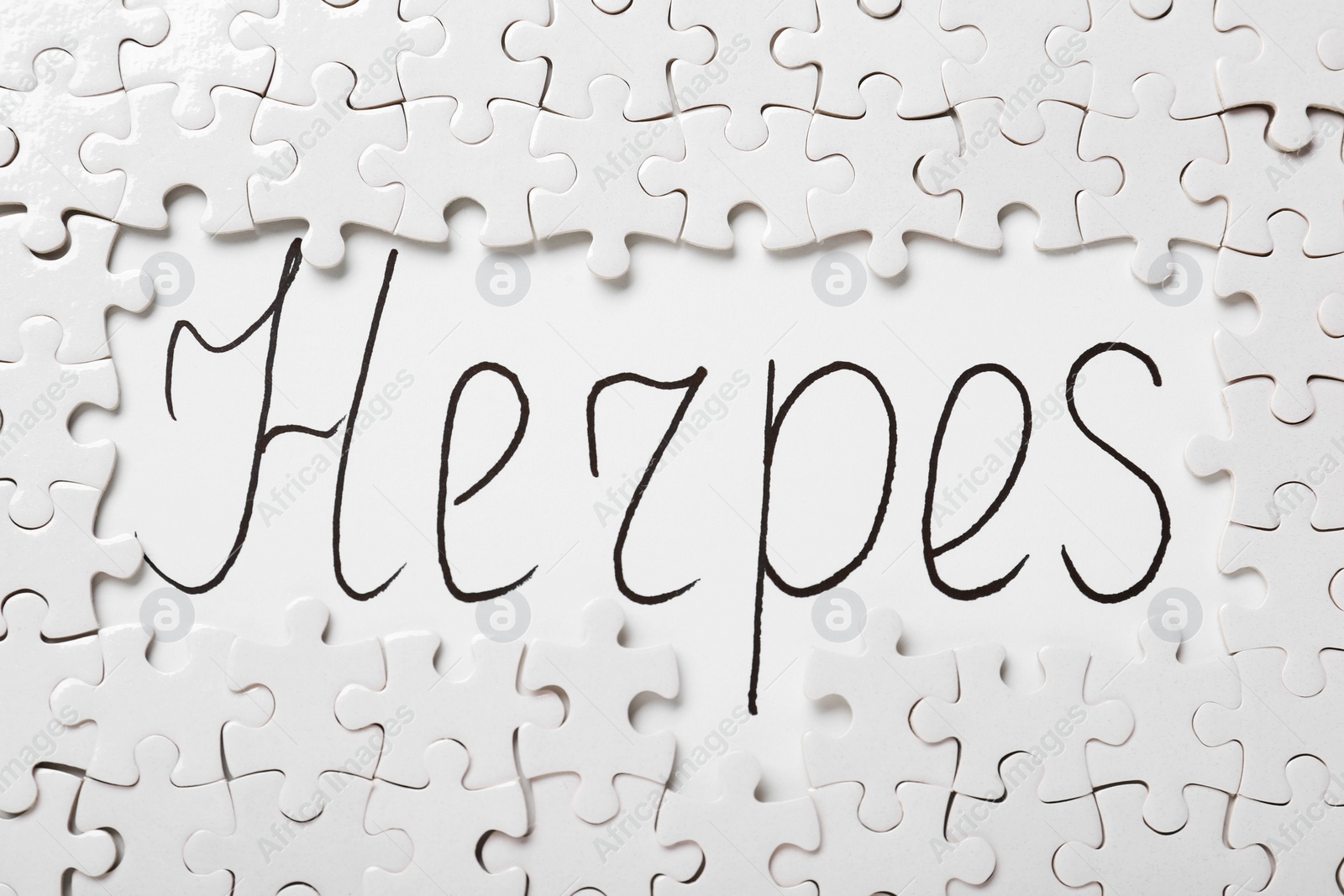 Photo of Puzzle pieces and word Herpes written on white background, flat lay