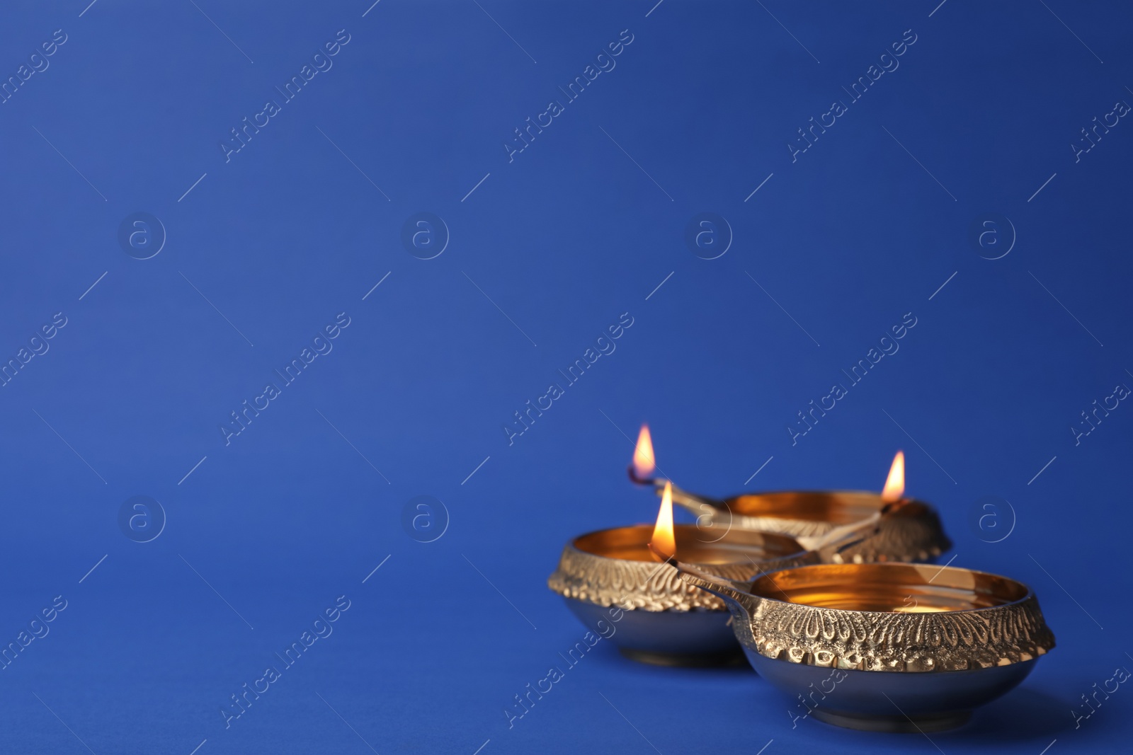 Photo of Diwali diyas or clay lamps on color background