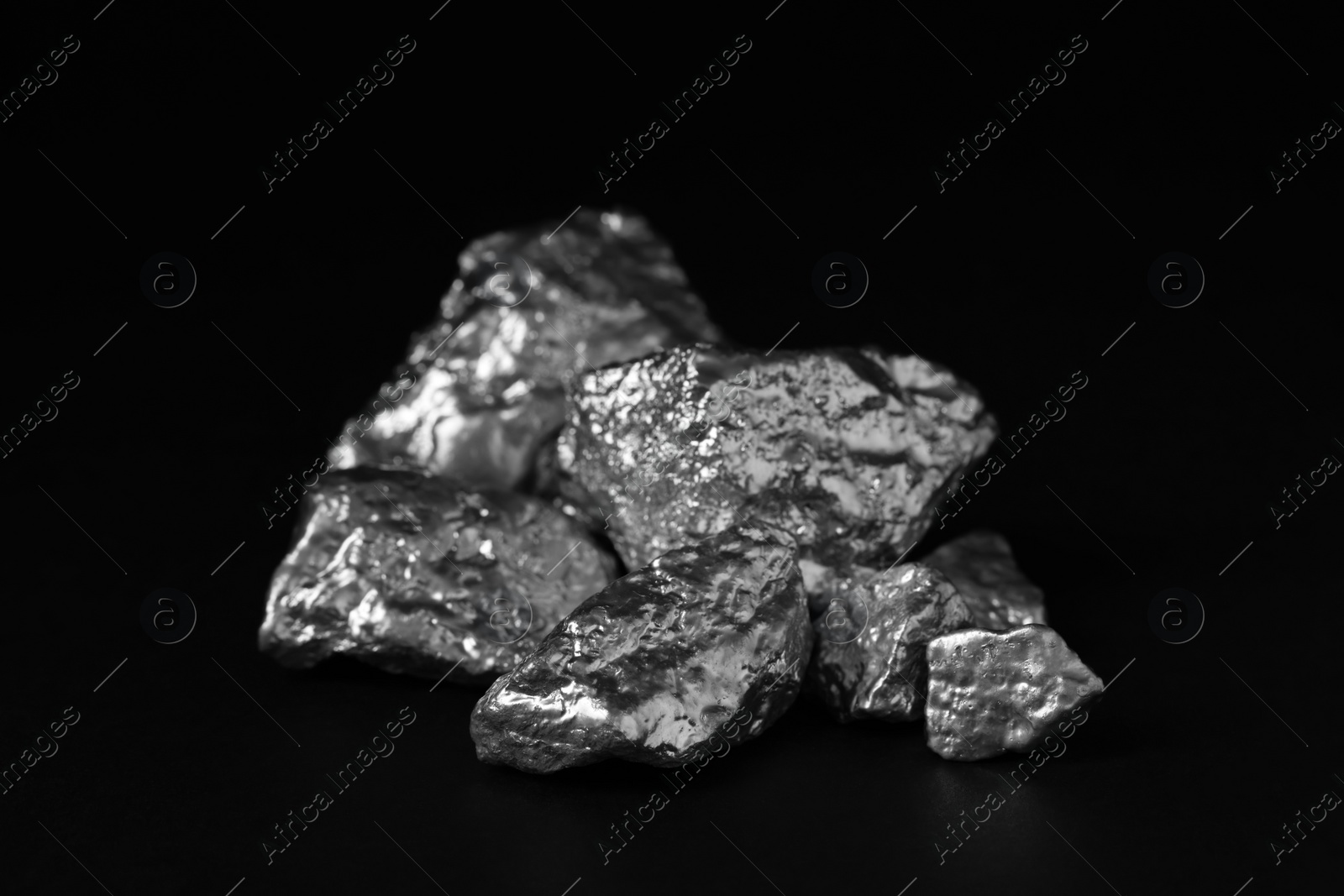 Photo of Pile of silver nuggets on black background, closeup