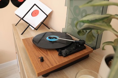 Vinyl record player on wooden table indoors