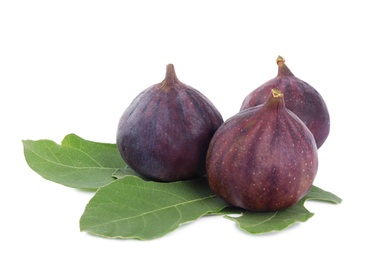 Photo of Fresh juicy purple figs and green leaves on white background