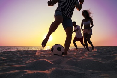 Photo of Friends playing football on beach at sunset, closeup