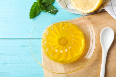 Photo of Delicious yellow jelly on light blue wooden table, flat lay