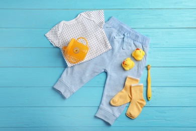 Photo of Flat lay composition with cute clothes on wooden background. Baby accessories