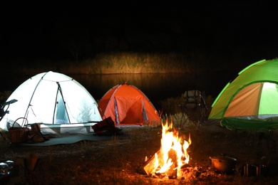 Photo of Bonfire near camping tents outdoors at night