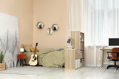 Photo of Stylish teenager's room interior with comfortable bed and workplace