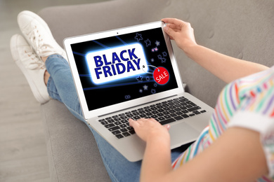 Image of Black Friday. Woman shopping online using laptop at home, closeup