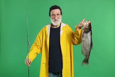 Photo of Fisherman with rod and catch on green background