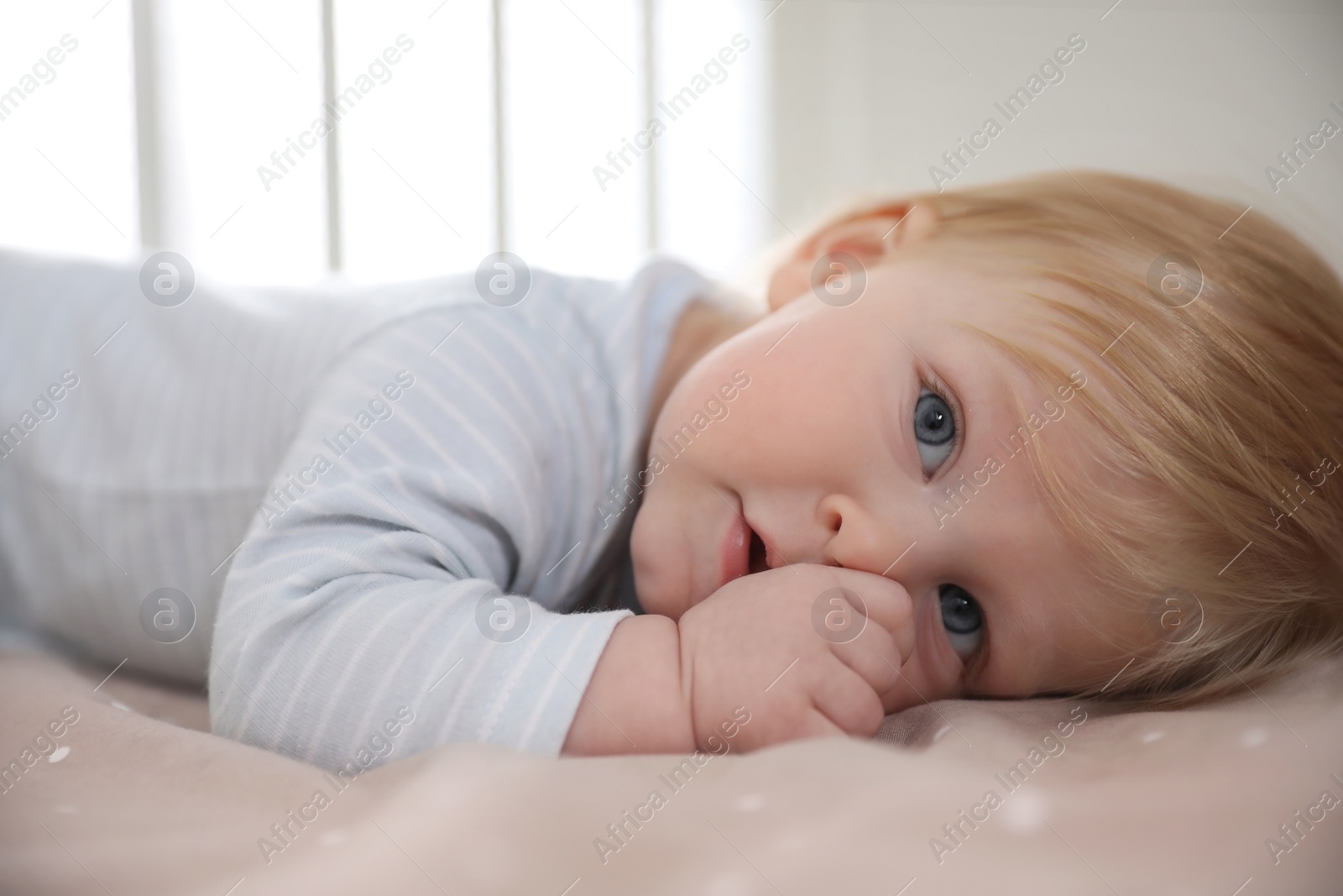 Photo of Adorable little baby lying in comfortable crib