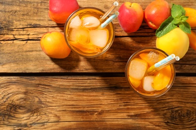 Photo of Delicious refreshing drink with apricot on wooden table, flat lay. Space for text