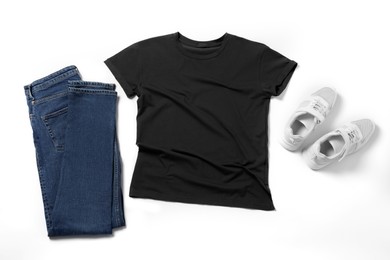 Photo of Stylish t-shirt, jeans and sneakers on white background, flat lay