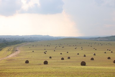 Photo of Beautiful view of agricultural field with hay bales