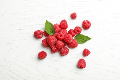 Photo of Ripe aromatic raspberries on wooden table, top view