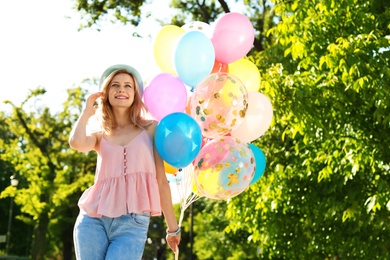 Photo of Young woman with colorful balloons outdoors on sunny day