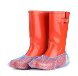 Photo of Rubber boots in blue shoe covers isolated on white