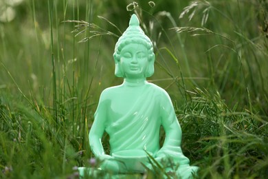 Photo of Decorative Buddha statue in green grass outdoors